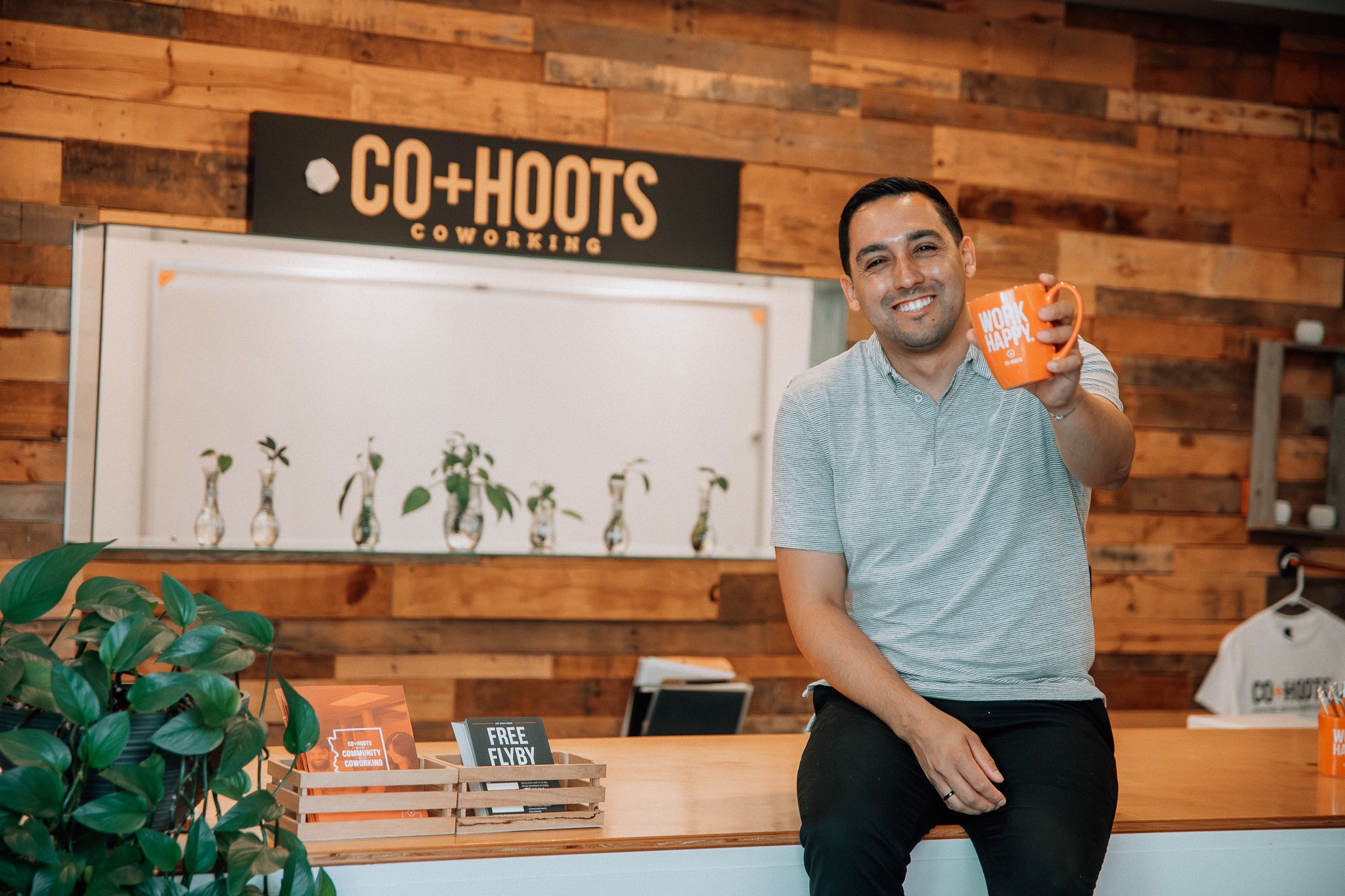 Jaime Munoz, Owner and CEO, smiles warmly while raising a coffee mug in a toast, creating a welcoming and friendly atmosphere.